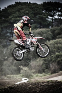 Fotografía de deportes extremos con un piloto de motocross dando un salto con la moto