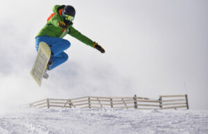 Fotografía de deportes extremos con un snowboarder dando un salto 